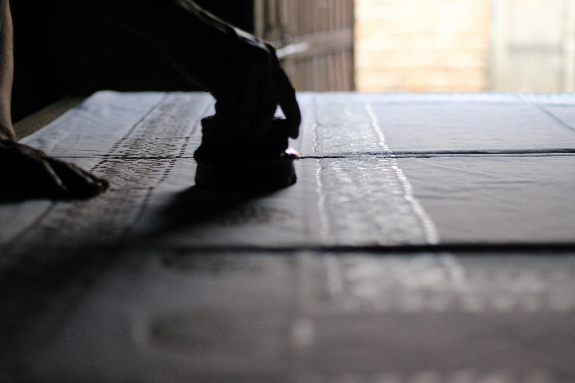 Someone is stamping a pattern onto fabric.